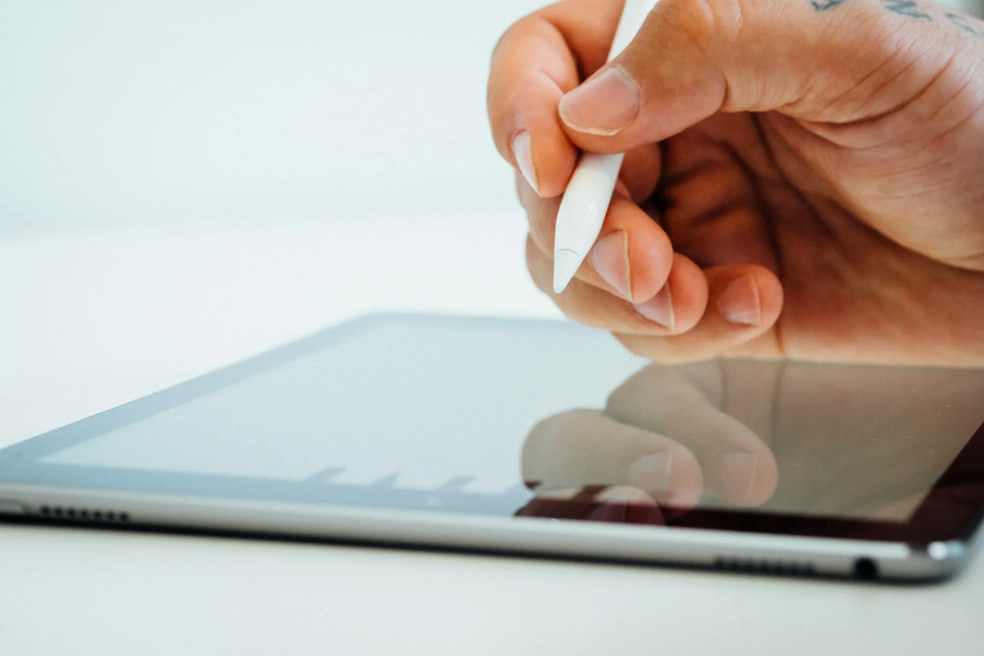 Hand mit einem Eingabestift über einem Tablet